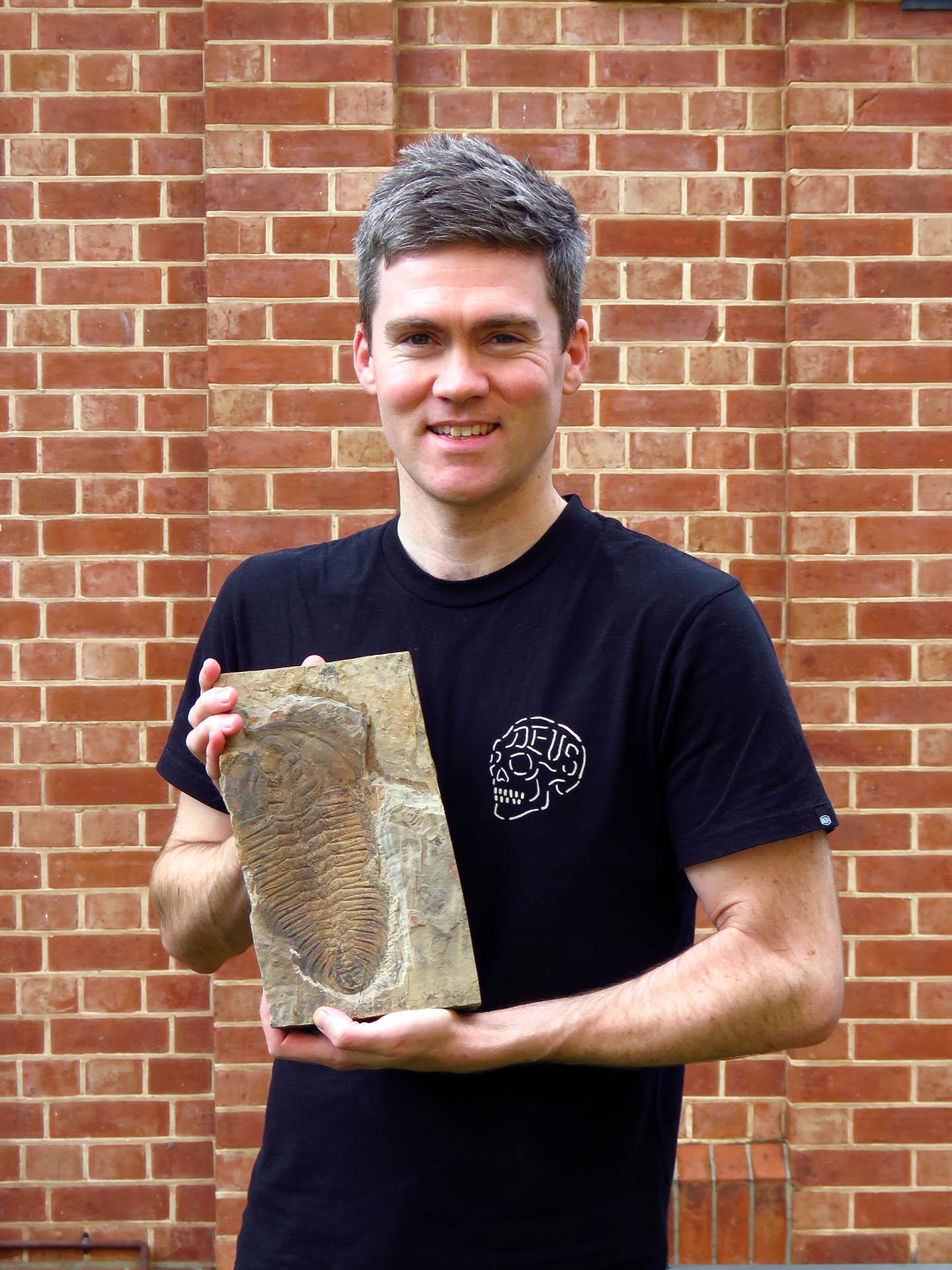 Lead researcher James Holmes, University of Adelaide, with a fossil of the giant new trilobite species Redlichia rex